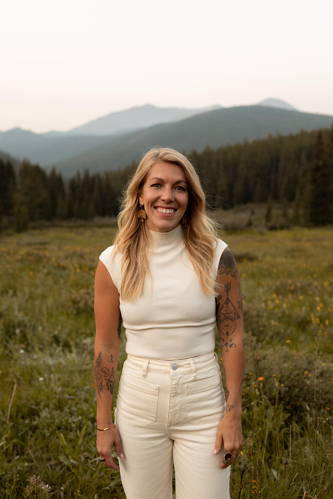 Sarah Creech, functional nutritional therapy practitioner, standing in a mountain meadow
